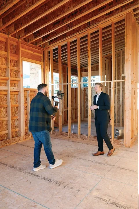 Two people reviewing the framing inside the Skyridge home during construction